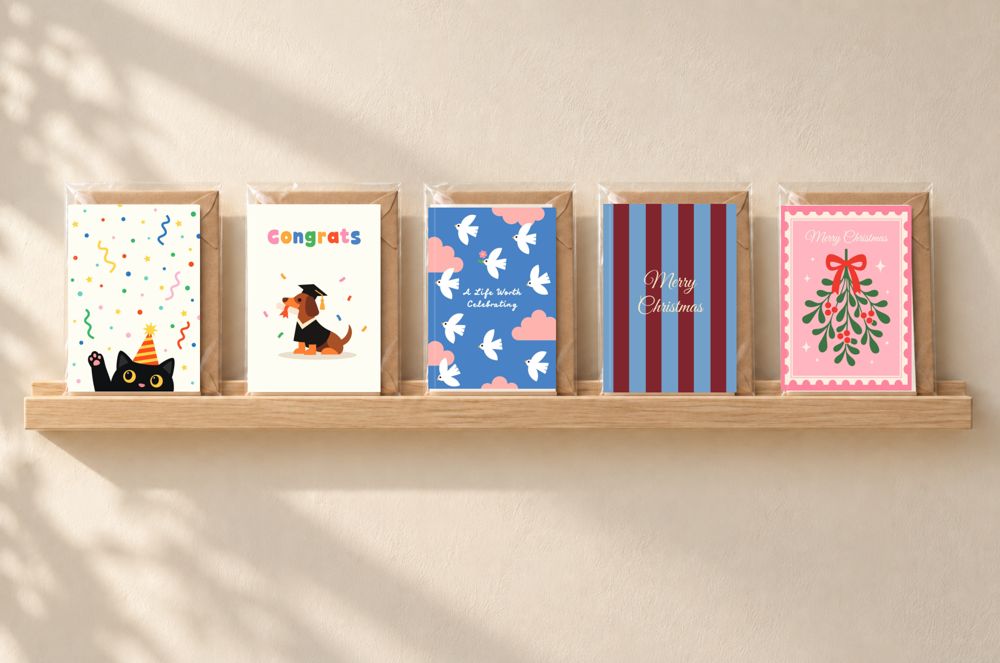 Five KOLOS wishcards on a wooden shelf in a shop